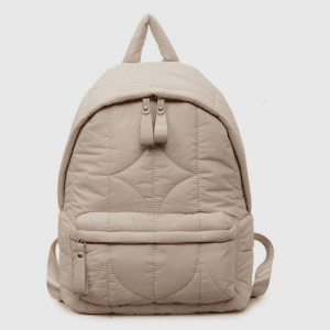 A front view of a beige quilted puffer backpack with curved stitching and a front zipper pocket on a white background.