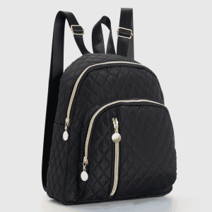 A black quilted mini backpack with a front zip pocket and adjustable shoulder straps standing on a white surface.