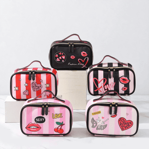 Five PU leather makeup bags in various pop art designs and stripes arranged on white display blocks.